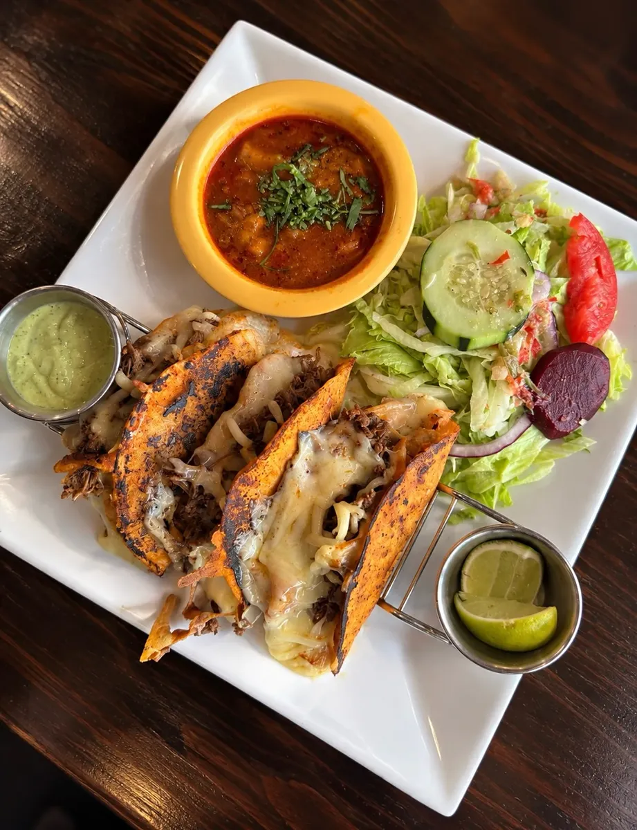 Tacos with melted cheese, salsa verde and a side salad