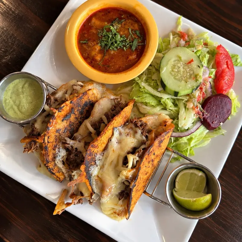 Tacos with melted cheese, salsa verde and a side salad